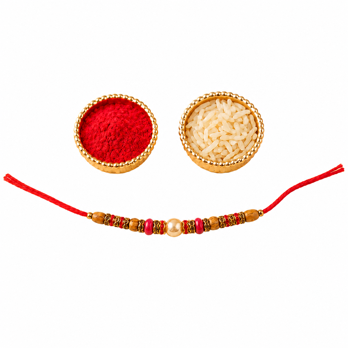 A traditional Indian rakhi with red thread and gold-toned beads, displayed horizontally with two small bowls containing red powder and white rice on a plain white background.